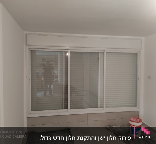 חלון אלומיניום עם תריסים סגורים בחדר